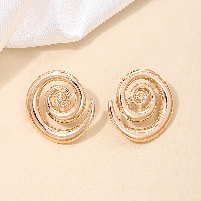 Boucles d'oreilles tourbillonnantes creuses de style simple Boucles d'oreilles de rue exagérées
